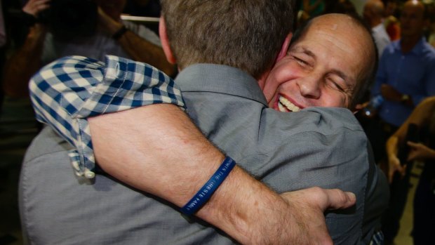 He's home: Peter Greste embraces a friend on returning to Australian soil.
