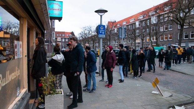 People queue to buy marijuana at coffeeshop Bulwackie in Amsterdam, Netherlands, after health minister Bruno Bruins ordered all Dutch schools, cafes, restaurants, coffeeshops and sport clubs to be closed.