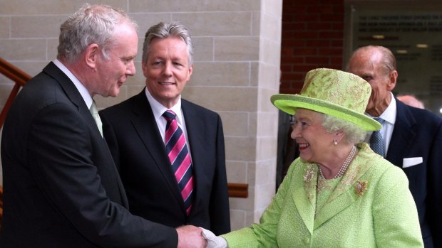 The Queen shakes hands with Martin McGuinness, watched by then first minister Peter Robinson, centre, at the Lyric Theatre in Belfast in June 2012.