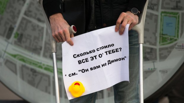 A man holds a poster with a yellow duck toy in Moscow over the weekend.