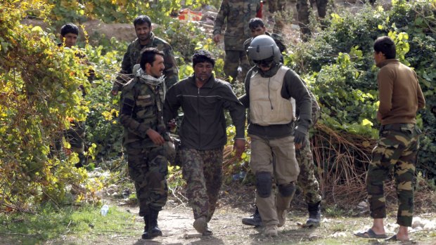 A member of the Afghan air force, second right, assists a wounded Afghan National Army soldier, in Uruzgan province, Afghanistan, on Tuesday. 