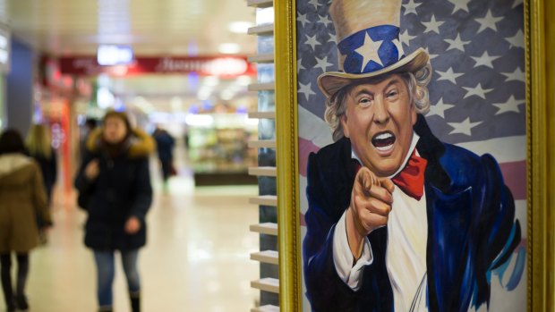 People walk past a caricature picture of US President Donald Trump in a shopping mall in Moscow on Wednesday.