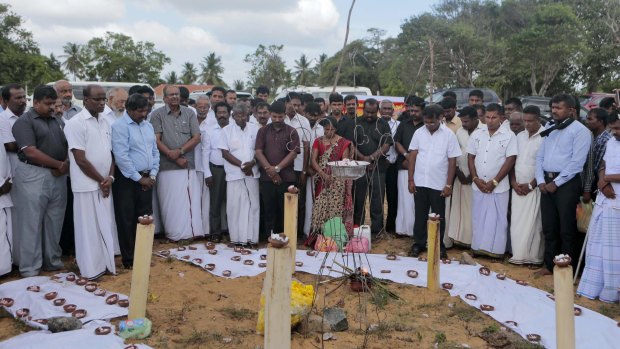Sri Lankan ethnic Tamil political activists observe silence near a makeshift monument, where thousands of people were killed in fierce fighting between the army and Tamil Tiger rebels.
