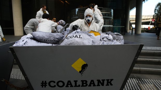 Greenpeace activists deliver a load of coal to the front of the Commonwealth Bank's Harbour Street office in Sydney on Monday to highlight the consequences of its fossil fuel lending policies.