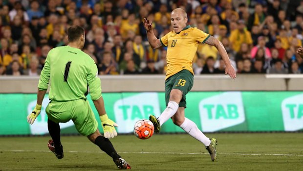 Kyrgyzstan goalkeeper Matiash Pavel blocks a shot from Aaron Mooy.