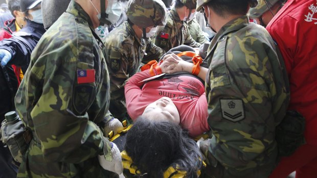 A woman is carried from the collapsed building in Tainan.