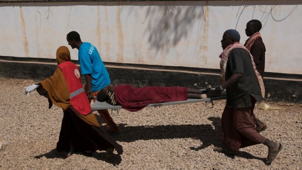 An ailing man is rushed into a cholera treatment centre in Baidoa, Somalia.