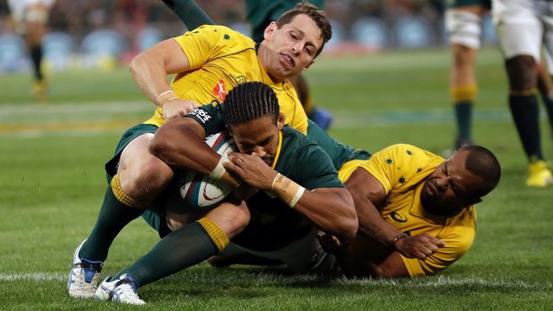 Too strong: Courtnall Skosana crosses as Bernard Foley and Kurtley Beale attempt to stop him.