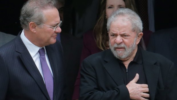 Former Brazilian president Luiz Inacio Lula da Silva, right, and Senate President Renan Calheiros, chat at the end of a breakfast with senators of the government's allied base, in Brasilia, on Wednesday, before charges were laid.