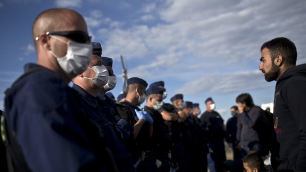Hungarian police officers wearing masks stand guard at a temporary detention centre for asylum seekers in Roszke, Hungary, in September. 