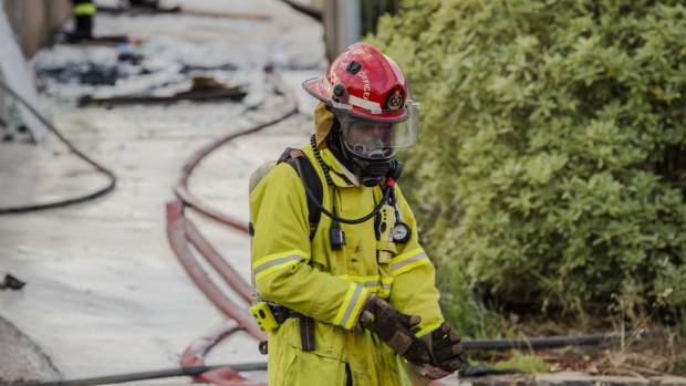 A firefighter on the scene of a house fire at Kinsella Street at Karabar on Friday.