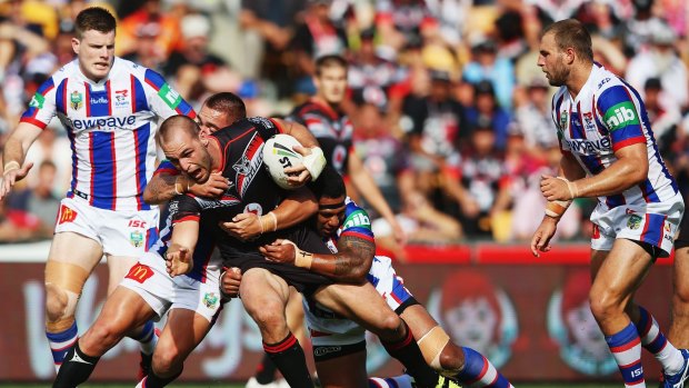 Struggling to break the line: Warriors veteran Simon Mannering is brought down by the Newcastle Knights at Mt Smart Stadium.