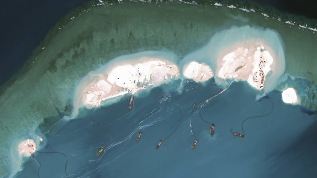 A handout satellite image shows dredgers working at the northernmost reclamation site of Mischief Reef, part of the Spratly Islands, in the South China Sea, March 16, 2015.