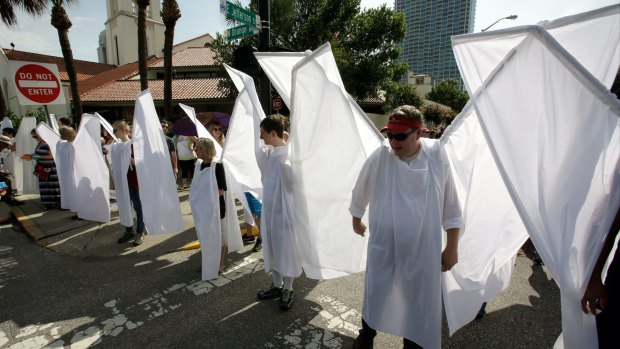 Counter demonstrators dressed as angels to show support and solidarity block the view of protesters near the funeral service for Christopher Andrew Leinonen, one of the victims of the Pulse shooting.