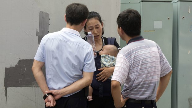 Yuan Shanshan, the wife of detained Chinese lawyer Xie Yanyi, is questioned by plain clothes security personnel near the Tianjin No. 2 Intermediate People's Court.
