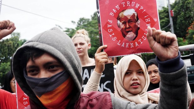People hold placards during a protest against US President Donald Trump in front US Embassy in Jakarta in February.