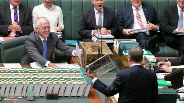 Opposition Leader Bill Shorten wields a newspaper with a report on Medicare changes during question time.