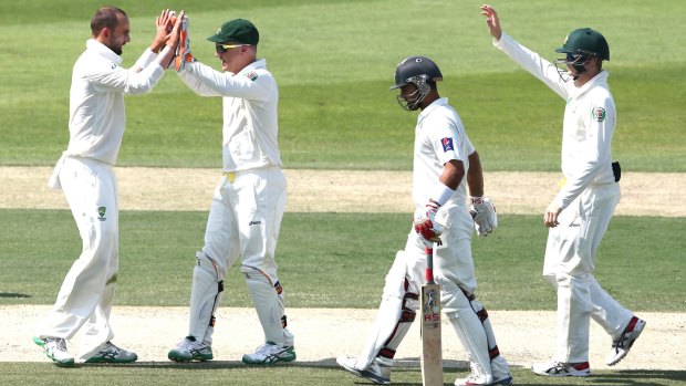 Nathan Lyon is congratulated after picking up the only wicket before lunch, trapping Ahmed Shehzad in front for 35.
