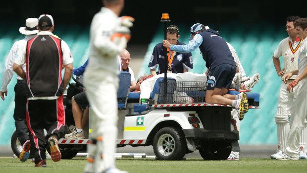 Phil Hughes is placed on a medicab at the SCG on Tuesday.