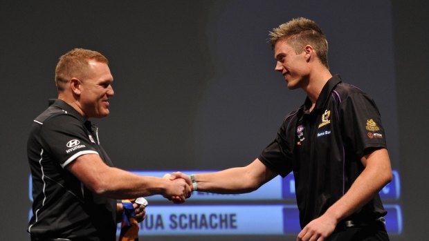 Number 2 draft pick Joshua Schache shakes hands with Juston Leppitsch, coach of Brisbane.