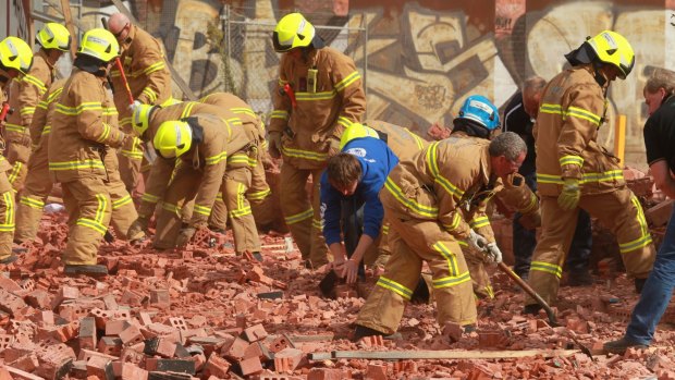 Firemen and workers dig through the debris after the wall collapse in March 2013.