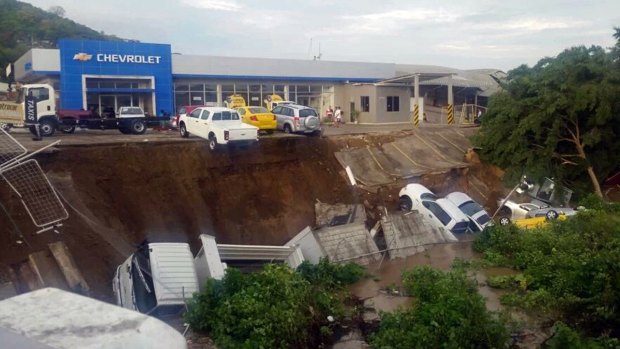 Vehicles from a car dealership hang on a precipice after an earthquake in Ecuador on Sunday. 