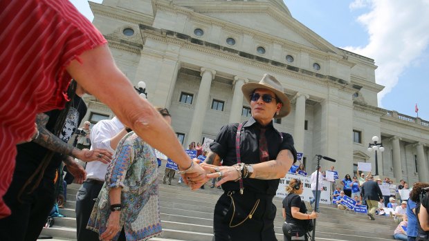 Actor Johnny Depp walks to the podium to speak at a rally opposing Arkansas' series of executions.