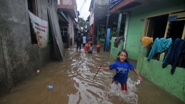 Children play on flooded streets after heavy monsoon rains in Bukit Duri, Jakarta, Indonesia on Tuesday.
