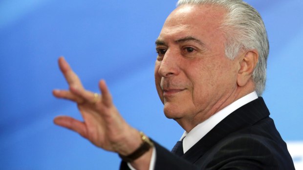 Brazilian President Michel Temer waves after attending a ceremony at the Planalto Presidential Palace, in Brasilia, on Monday.