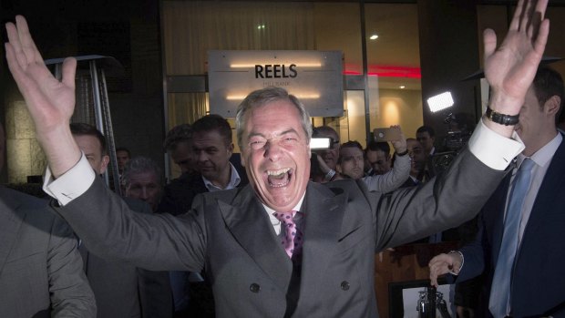 Nigel Farage, the leader of the UK Independence Party, celebrates and poses for photographers as he leaves a "Leave EU" party on Friday.