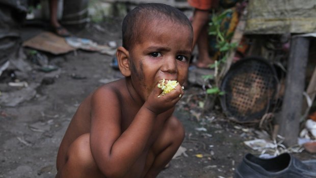 An Indian child eats rice at a slum area in Gauhati, India.