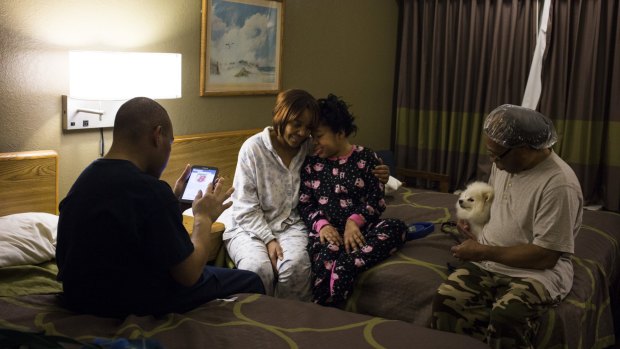 Darline Long, second from left, and her family at a hotel in Burton, Michigan. The family pays for a hotel room outside Flint once a month to take long showers and baths without worries. Long said the visits were therapeutic for her daughter, Wendy, third from left, who has cerebral palsy. 