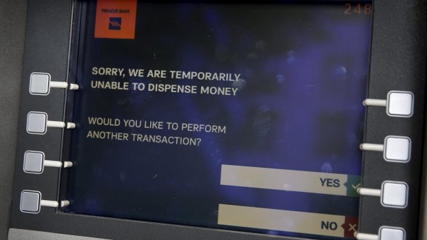 A message is displayed on the monitor of a Piraeus Bank ATM in Athens. 