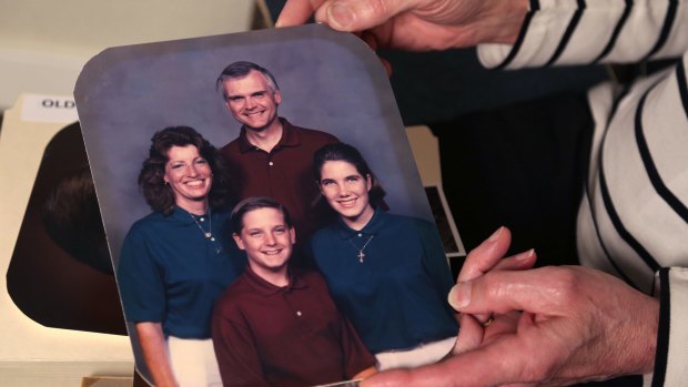 Kate holds a 1990s family photo showing her as Bill, with Linda and their children Matt and Megan.