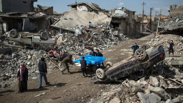 Residents carry the bodies of several people killed in air strikes on the western side of Mosul last week.