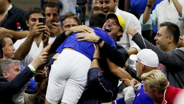 Jumping for joy: Novak Djokovic rejoices with his entourage.