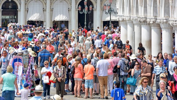 Crowds on the Riva degli Schiavoni promenade in Venice on a hot summer's day.