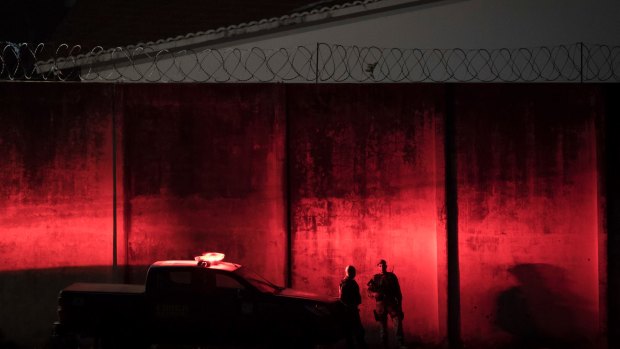 Police stand guard outside the Alcacuz prison amid tension between rival gangs at dusk in Nisia Floresta, near Natal, Brazil.