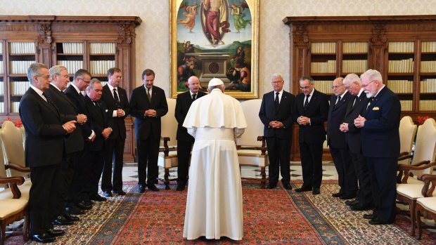 The Grand Master of the Knights of Malta, Giacomo Dalla Torre del Tempio di Sanguinetto, 7th from left, and his delegation are led in prayer by Pope Francis during a private audience at the Vatican in June.