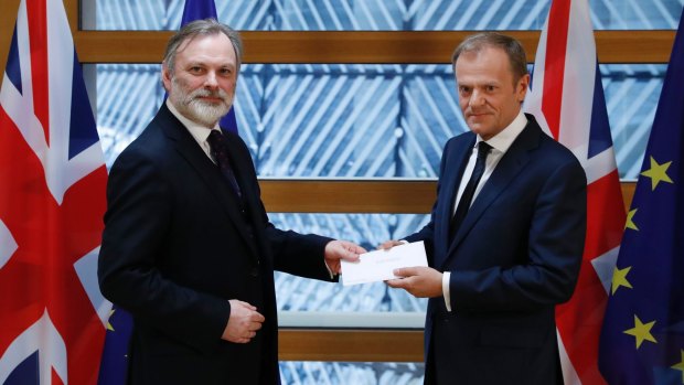 Sir Tim Barrow, the UK's permanent representative to the EU, left, hands the letter triggering Brexit to European Council President Donald Tusk in Brussels.