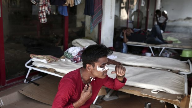 A migrant shaves himself inside an abandoned hotel where dozens of migrants have been living the last weeks at Kos town, Greece.