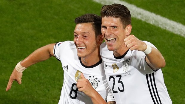 Victorious: Germany's Mesut Ozil  celebrates with teammate Mario Gomez after scoring his side's first goal.