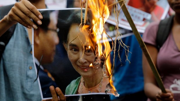 Reputation going up in flames: activists burn a poster of Aung San Suu Kyi.