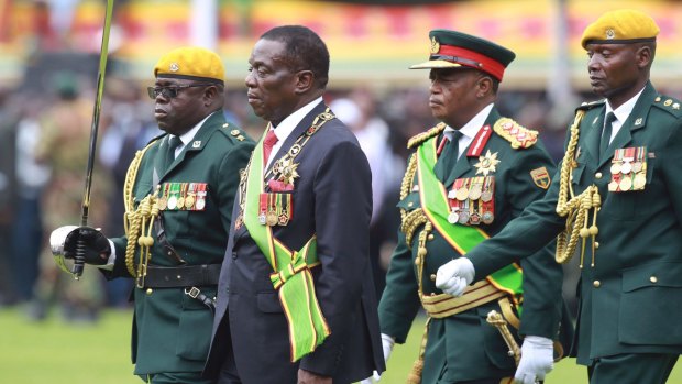 Emmerson Mnangagwa, second left, with coup-leader Army General Constantino Chiwenga, second right, inspects the military parade after being sworn.