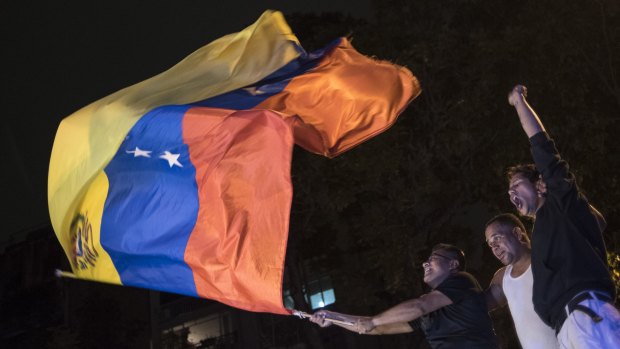 A man waves the Venezuelan national flag after hearing the results of the national congressional elections in Caracas.
