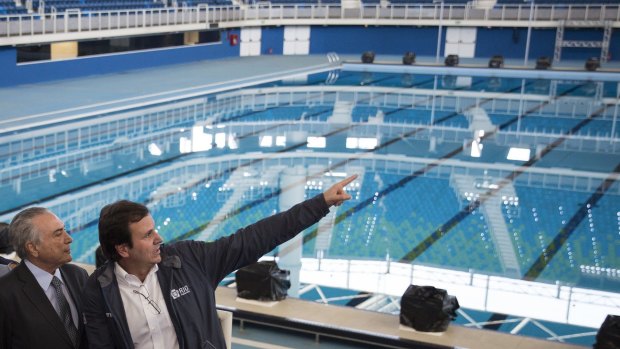 Brazil's interim President Michel Temer, left, talks to Rio de Janeiro Mayor Eduardo Paes at the Olympic Aquatics Stadium. Mr Temer says all venues are ready. 