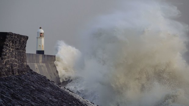 Waves crash against the harbour wall on in Porthcawl, United Kingdom. 