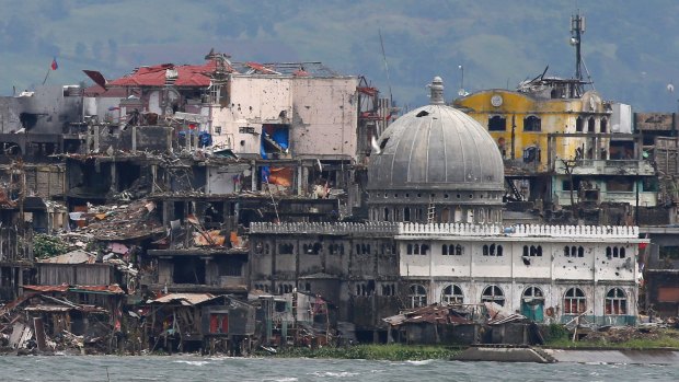 A mosque with its dome blasted out with holes is among destroyed buildings in battle-scarred Marawi,Philippines.