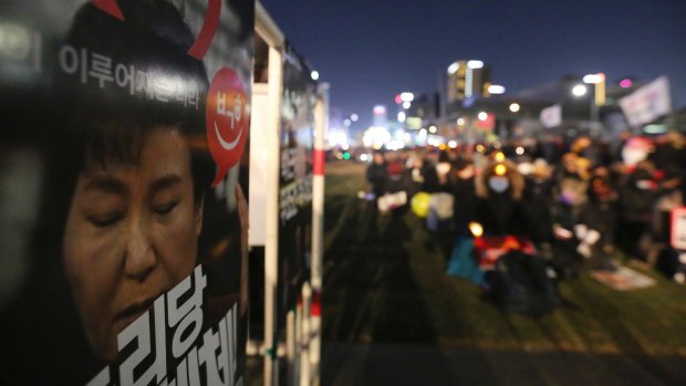 A poster showing a portrait of impeached President Park Geun-hye is displayed during a candle light vigil calling for Park to step down in Seoul.