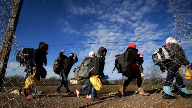 Refugees walk towards the border with Serbia from the transit centre for refugees near the northern Macedonian village of Tabanovce.